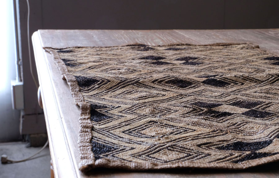 ラフィアヤシを平織りに織り、ラフィアの糸を刺繍して模様を作り